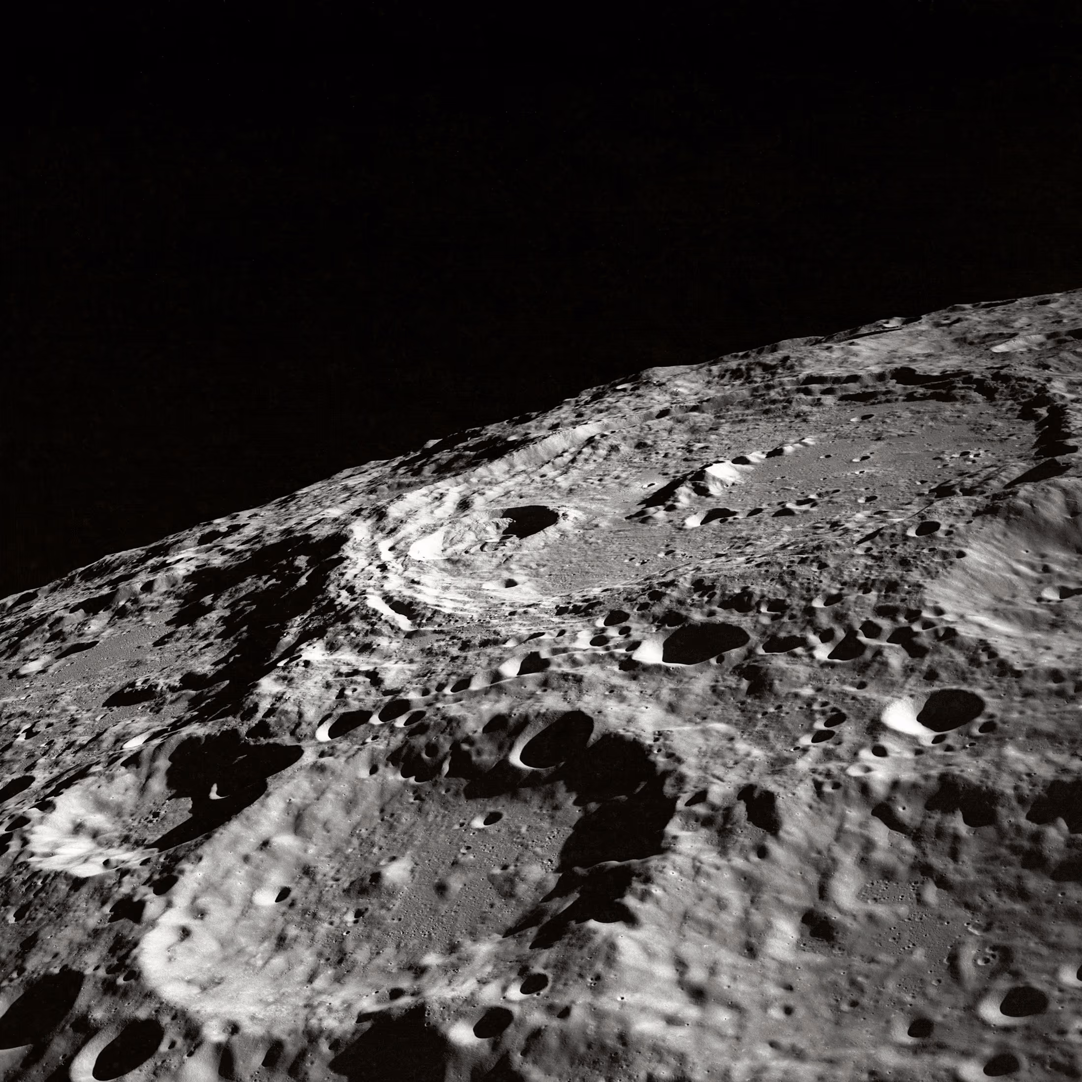 Relief lunaire texturé, surface minérale en lumière rasante.